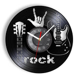 une horloge murale rock en vinyle noir qui montre une guitare, un main avec le signe de la corne et l'heure au centre.