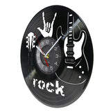 une horloge murale rock en vinyle noir qui montre une guitare, un main avec le signe de la corne et l'heure au centre de coté.