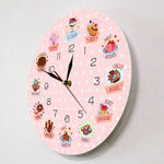 une horloge murale gâteau rose avec des patisseries comme illustration.